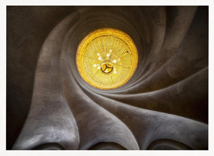 A worm's-eye view of an ornate, golden chandelier set against a swirling, textured dark grey ceiling. The spiraling architectural feature draws the eye to the brightly lit fixture, creating an abstract and dramatic composition. Poster