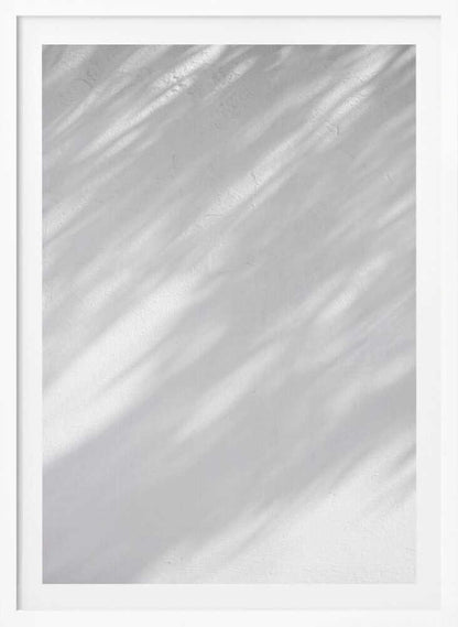 Diagonal leaf shadows cast on a white textured wall, creating a minimalist black and white art piece.