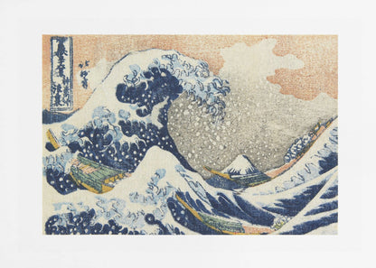 A framed print of Hokusai's 'The Great Wave off Kanagawa,' a Japanese ukiyo-e woodblock print. A huge, dark blue wave with white foam crests over small boats, with a snow-capped Mount Fuji in the distance under a pale orange sky. Artwork