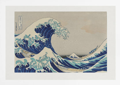 The Great Wave off Kanagawa by Hokusai, a framed Japanese woodblock print depicting a giant, menacing blue and white wave cresting over three boats, with a small Mount Fuji visible in the background under a muted, overcast sky. Artwork