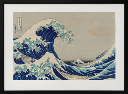 The Great Wave off Kanagawa by Hokusai, a framed Japanese woodblock print depicting a giant, menacing blue and white wave cresting over three boats, with a small Mount Fuji visible in the background under a muted, overcast sky. Artwork