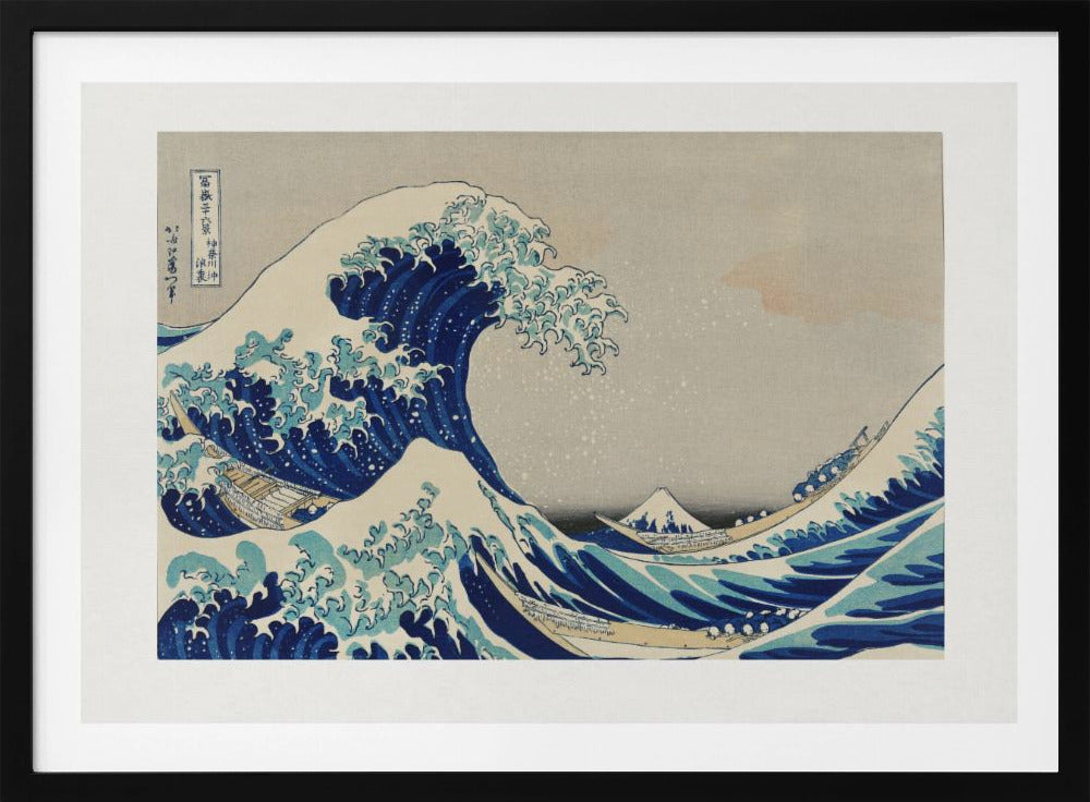 The Great Wave off Kanagawa by Hokusai, a framed Japanese woodblock print depicting a giant, menacing blue and white wave cresting over three boats, with a small Mount Fuji visible in the background under a muted, overcast sky. Artwork