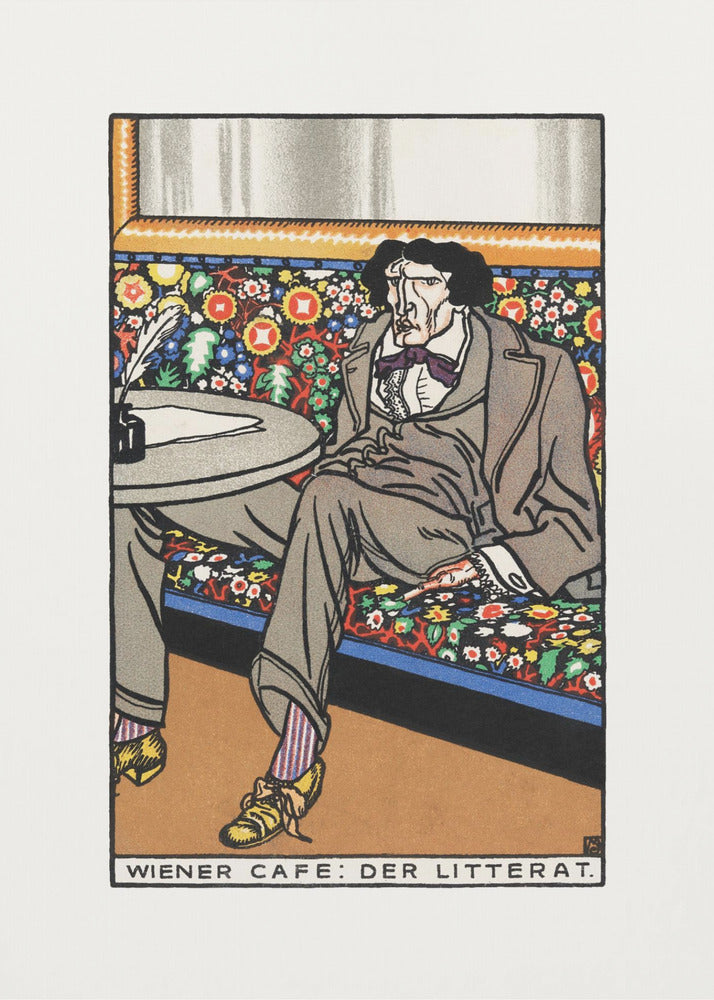 A framed art print titled 'Wiener Cafe: Der Litterat', depicting a stylized illustration of a writer in a Viennese cafe. The man, with a gaunt face and dark hair, sits on a brightly colored, floral-patterned bench, wearing a grey suit, striped socks, and yellow shoes. A table beside him holds an inkwell and quill. Decor
