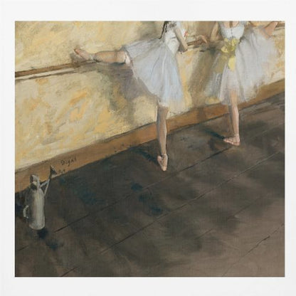 A framed impressionist painting by Edgar Degas depicting two ballet dancers in white tutus practicing at a barre. The studio has a yellow wall and a dark brown wooden floor. One dancer stretches her leg on the barre while the other stands beside her. Artwork