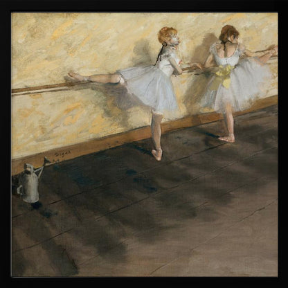 A framed impressionist painting by Edgar Degas depicting two ballet dancers in white tutus practicing at a barre. The studio has a yellow wall and a dark brown wooden floor. One dancer stretches her leg on the barre while the other stands beside her. Artwork