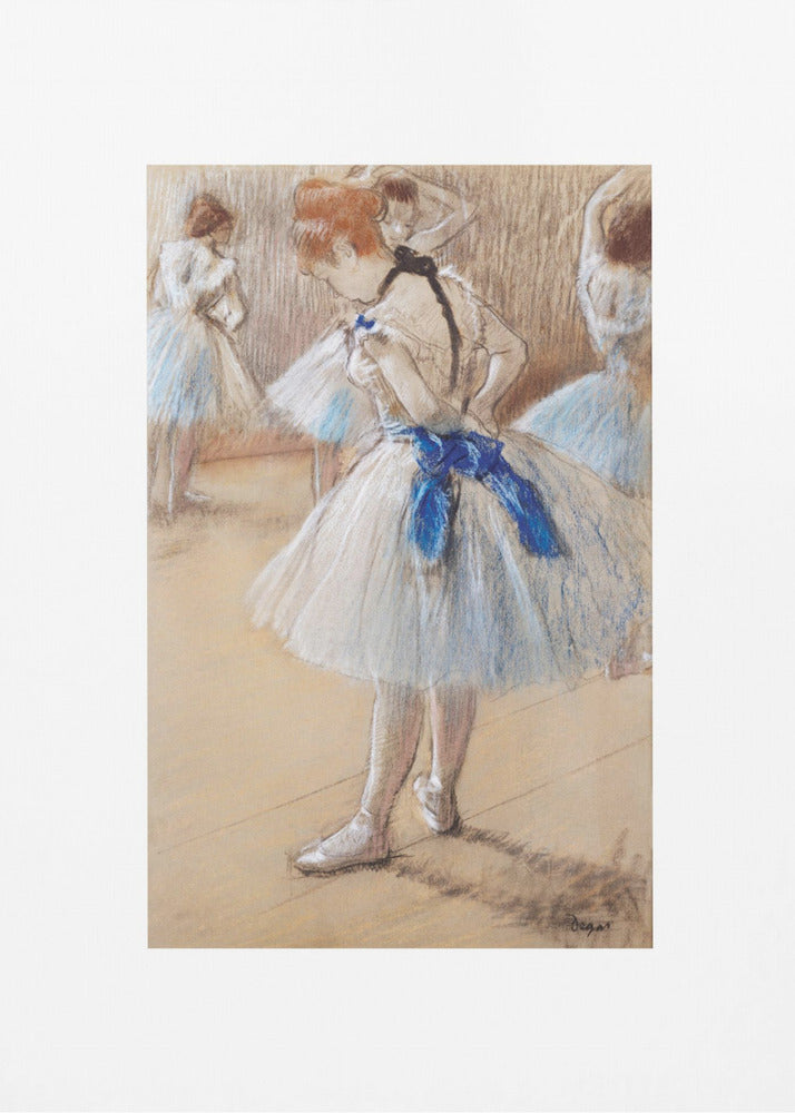 A framed print of an impressionist pastel drawing by Edgar Degas. It shows a ballerina in a white and light blue tutu with a prominent royal blue sash. She is viewed from the side as she adjusts her costume, with other dancers blurred in the background of a dance studio. Poster