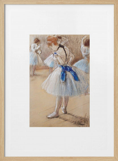 A framed print of an impressionist pastel drawing by Edgar Degas. It shows a ballerina in a white and light blue tutu with a prominent royal blue sash. She is viewed from the side as she adjusts her costume, with other dancers blurred in the background of a dance studio. Poster