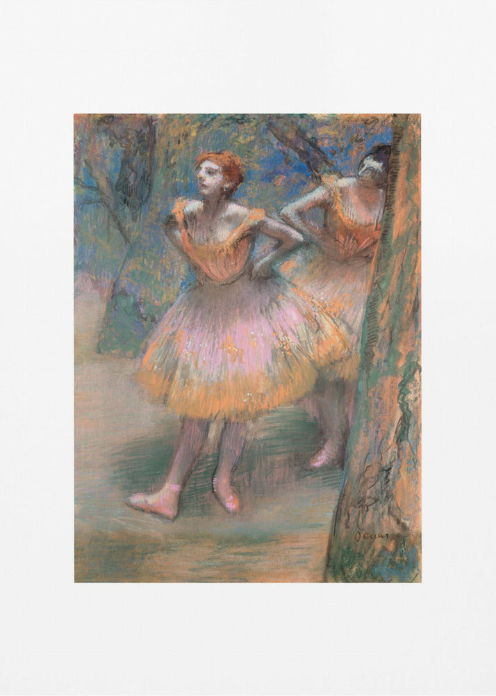 A framed vertical print of Edgar Degas's impressionist pastel drawing 'Dancers, Pink and Green'. It depicts two ballerinas in pink and orange tutus standing backstage amongst trees, captured in soft, expressive strokes. Artwork