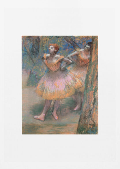 A framed vertical print of Edgar Degas's impressionist pastel drawing 'Dancers, Pink and Green'. It depicts two ballerinas in pink and orange tutus standing backstage amongst trees, captured in soft, expressive strokes. Artwork
