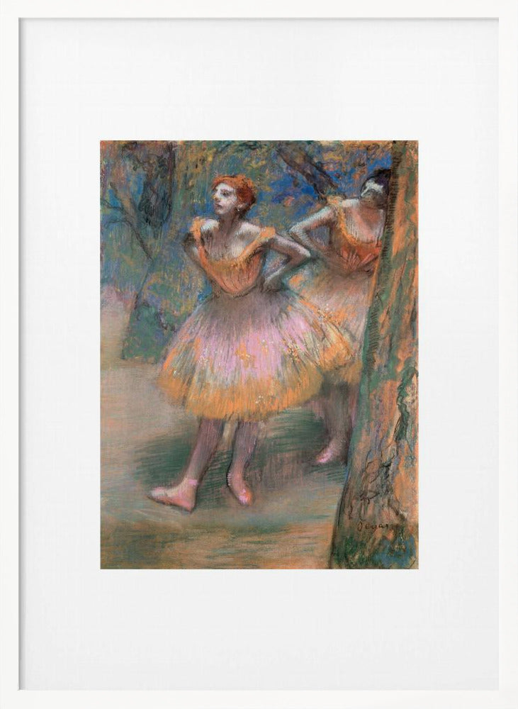 A framed vertical print of Edgar Degas's impressionist pastel drawing 'Dancers, Pink and Green'. It depicts two ballerinas in pink and orange tutus standing backstage amongst trees, captured in soft, expressive strokes. Artwork