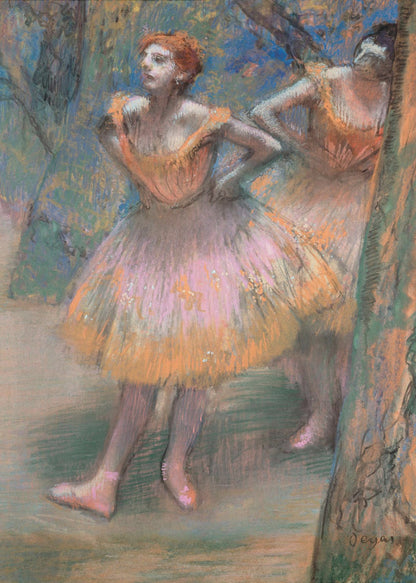 An impressionist pastel painting by Edgar Degas titled 'Dancers in Pink and Orange.' It depicts two ballerinas backstage. The dancer in the foreground has red hair, wears a pink and orange tutu, and stands with her hands on her hips, looking off to the side. A second dancer is partially visible behind her. The background is a textured blend of blues, greens, and browns. Artwork