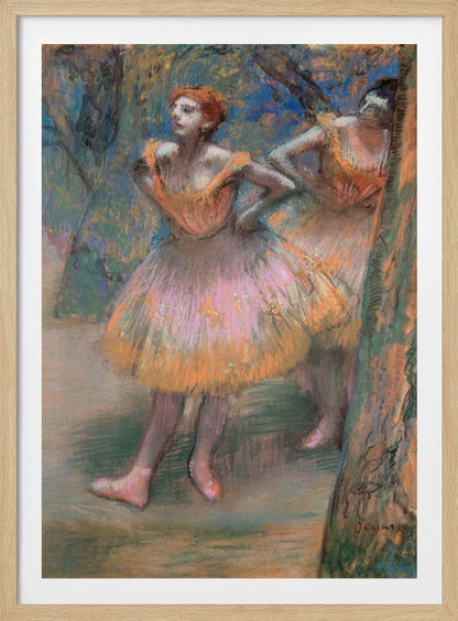 An impressionist pastel painting by Edgar Degas titled 'Dancers in Pink and Orange.' It depicts two ballerinas backstage. The dancer in the foreground has red hair, wears a pink and orange tutu, and stands with her hands on her hips, looking off to the side. A second dancer is partially visible behind her. The background is a textured blend of blues, greens, and browns. Artwork