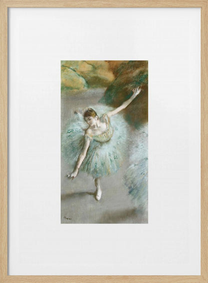 A framed vertical reproduction of an Edgar Degas painting showing a ballerina from a high angle. She wears a voluminous light blue tutu and is posed gracefully with arms outstretched against a soft, impressionistic background of earthy browns and tans. Poster