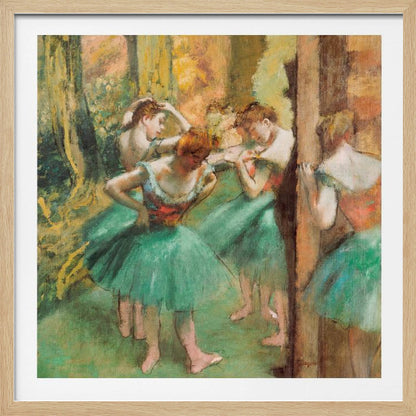 An impressionist painting of four ballet dancers in green tutus backstage. The dancers are adjusting their costumes and hair against a warm, painterly background of yellow, orange, and brown tones. The artwork is displayed in a light wood frame. Wall Art