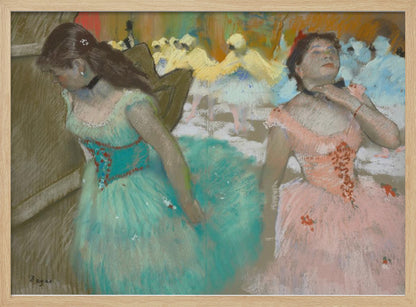 A framed pastel artwork by Edgar Degas depicting several ballerinas. In the foreground, a ballerina in a turquoise tutu looks down, while another in a pink tutu adjusts her collar with her eyes closed. In the background, more dancers in yellow and white are blurred on a stage. Wall Art