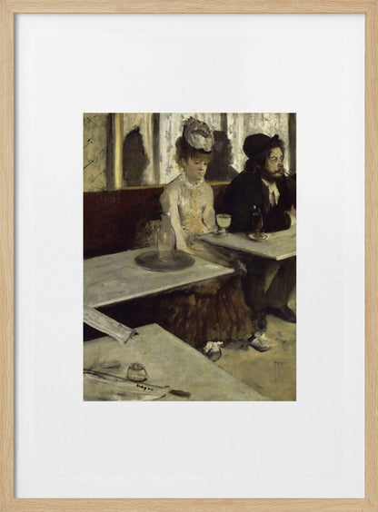 A framed print of Edgar Degas's painting 'L'Absinthe,' depicting a somber-looking man and woman sitting at adjacent tables in a 19th-century Parisian cafe, conveying a sense of alienation and melancholy. Print