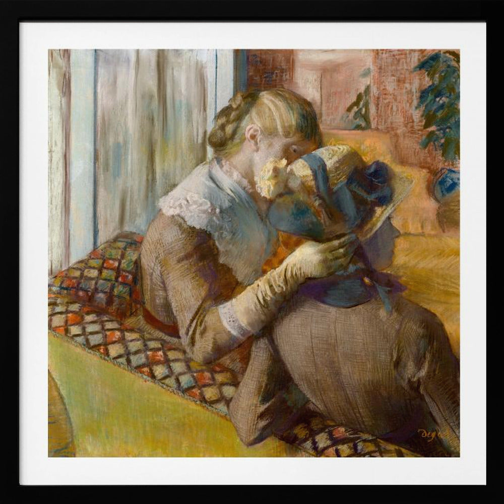 A framed Impressionist painting by Edgar Degas depicting two women. One woman, with blonde hair tied back, adjusts a hat with a blue ribbon on the other woman who is sitting with her back mostly to the viewer on a colorful patterned sofa. Print