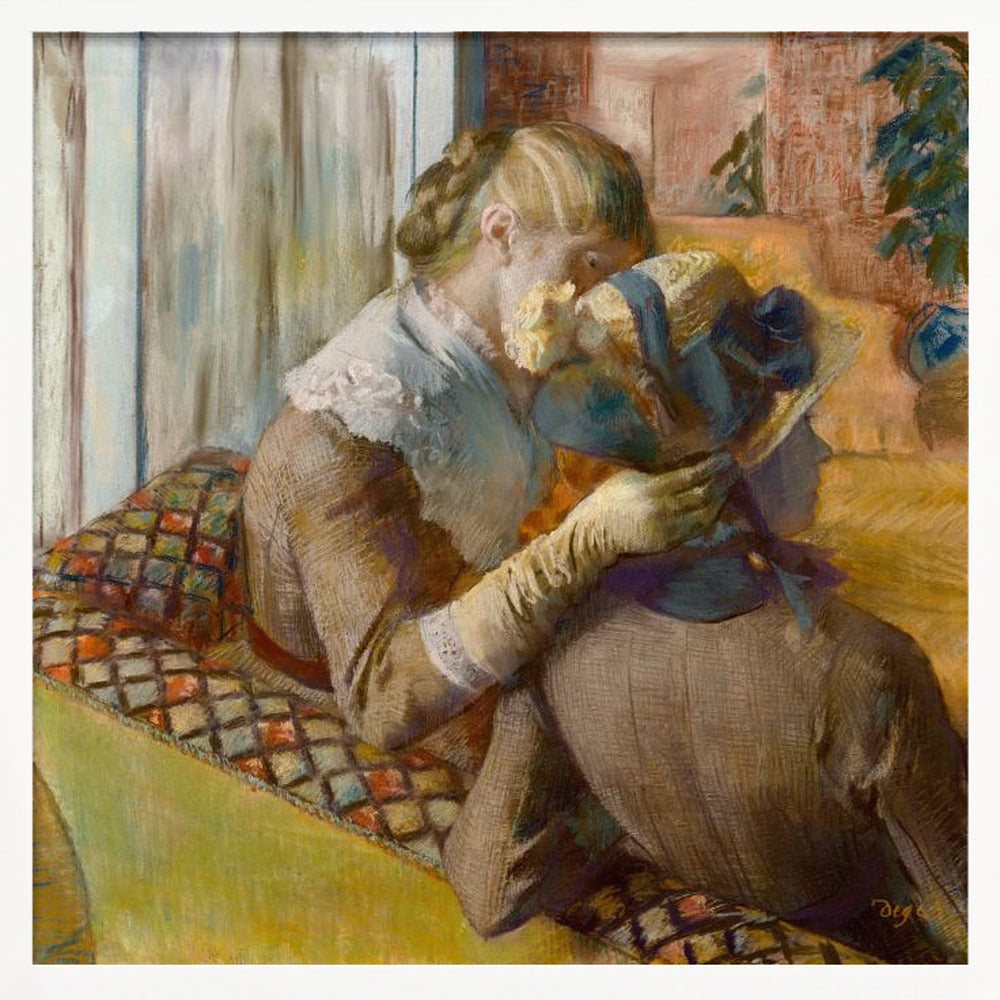 A framed Impressionist painting by Edgar Degas depicting two women. One woman, with blonde hair tied back, adjusts a hat with a blue ribbon on the other woman who is sitting with her back mostly to the viewer on a colorful patterned sofa. Print