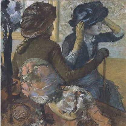 A framed impressionist painting by Edgar Degas, 'The Millinery Shop', depicting two women. One woman, seen from the back, wears a brown coat and hat, while the other tries on a dark blue hat, adjusting it with her gloved hands. Colorful hats are displayed in the foreground. Print