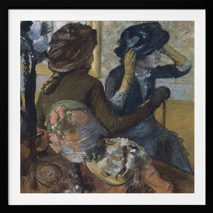 A framed impressionist painting by Edgar Degas, 'The Millinery Shop', depicting two women. One woman, seen from the back, wears a brown coat and hat, while the other tries on a dark blue hat, adjusting it with her gloved hands. Colorful hats are displayed in the foreground. Print