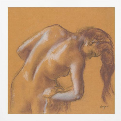 A framed pastel sketch by Edgar Degas titled 'After the Bath, Woman Drying Herself'. The artwork depicts a nude woman from the back, bending forward as if drying herself. The drawing is on a warm ochre-colored paper, with her form defined by brown lines and white highlights, especially along her spine and shoulders. Her long brown hair cascades down on the right side. Wall Art