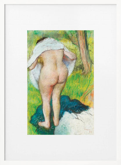 A framed pastel artwork by Edgar Degas showing the back of a nude woman as she dries herself with a white towel in a lush green landscape. The impressionist style is evident in the soft, textured application of color. Artwork