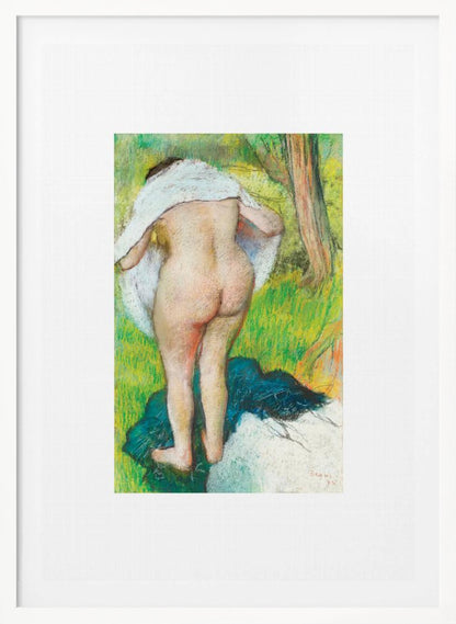 A framed pastel artwork by Edgar Degas showing the back of a nude woman as she dries herself with a white towel in a lush green landscape. The impressionist style is evident in the soft, textured application of color. Artwork