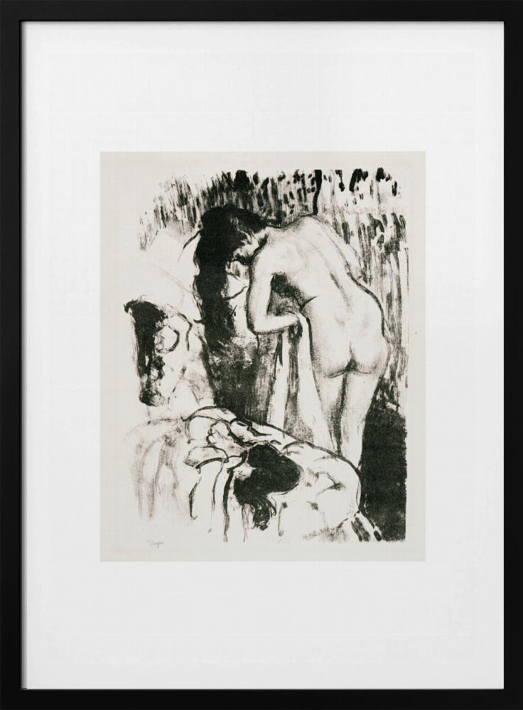 A framed black and white lithograph by Edgar Degas of a nude woman with long dark hair, viewed from the back as she leans over. The artwork has a sketchy, impressionistic style, capturing an intimate moment. Wall Art