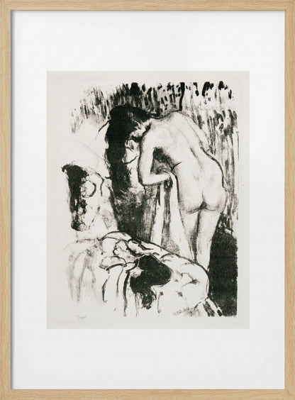 A framed black and white lithograph by Edgar Degas of a nude woman with long dark hair, viewed from the back as she leans over. The artwork has a sketchy, impressionistic style, capturing an intimate moment. Wall Art