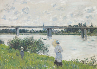 A scenic landscape art print by Claude Monet titled 'The Promenade With the Railroad Bridge, Argenteuil', depicting people on a promenade alongside a body of water with a railroad bridge in the background, characteristic of Impressionist style with soft colors and brushstrokes. Print
