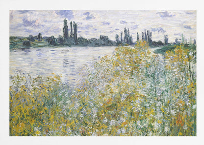 An impressionist landscape painting of a riverbank covered in yellow and white wildflowers. A calm river reflects the cloudy sky, and the opposite bank is lined with tall, dark poplar trees. The artwork is displayed in a silver frame. Artwork