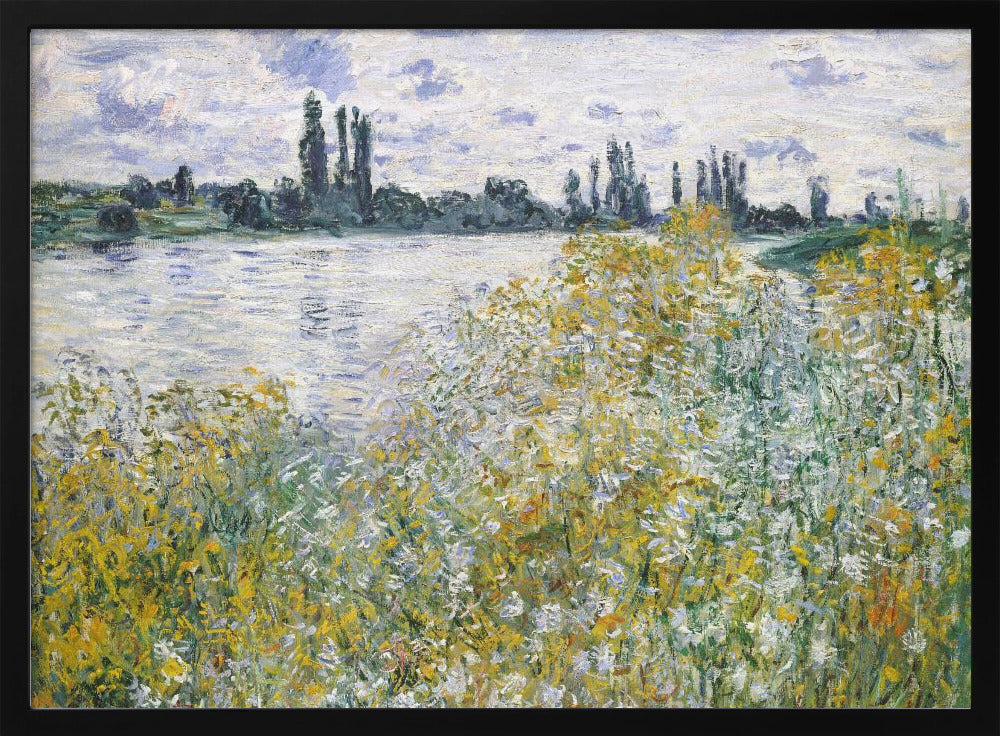 An impressionist landscape painting of a riverbank covered in yellow and white wildflowers. A calm river reflects the cloudy sky, and the opposite bank is lined with tall, dark poplar trees. The artwork is displayed in a silver frame. Artwork