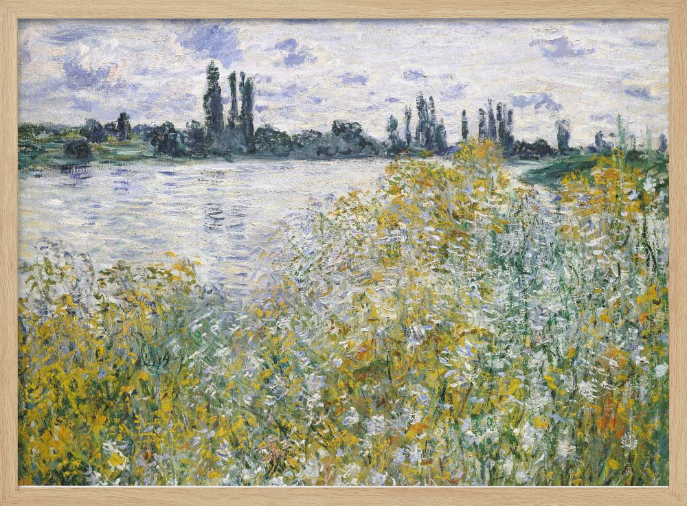 An impressionist landscape painting of a riverbank covered in yellow and white wildflowers. A calm river reflects the cloudy sky, and the opposite bank is lined with tall, dark poplar trees. The artwork is displayed in a silver frame. Artwork