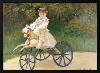 An Impressionist painting by Claude Monet depicting his son, Jean, riding a toy horse tricycle. The young boy wears a brown hat and a light-colored outfit, sitting on a white hobby horse with large blue wheels, set against a lush green garden background. Decor