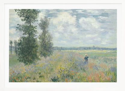 An impressionist painting by Claude Monet titled 'Poppy Field near Vétheuil', depicting a vast field of green grass dotted with red, yellow, and purple wildflowers. A figure in a white bonnet stands in the field to the right. Tall green trees are on the left, under a blue sky with fluffy white clouds. The entire scene is presented within a modern silver frame. Wall Art