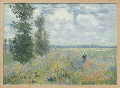 An impressionist painting by Claude Monet titled 'Poppy Field near Vétheuil', depicting a vast field of green grass dotted with red, yellow, and purple wildflowers. A figure in a white bonnet stands in the field to the right. Tall green trees are on the left, under a blue sky with fluffy white clouds. The entire scene is presented within a modern silver frame. Wall Art