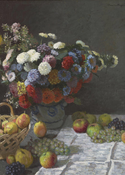 A classic still life painting by Claude Monet depicting a vibrant, multicolored bouquet of flowers in a ceramic vase. Scattered around the vase on a white tablecloth are various fruits, including apples, pears in a basket, and bunches of grapes, all set against a dark, moody background. Poster