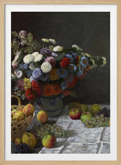 A classic still life painting by Claude Monet depicting a vibrant, multicolored bouquet of flowers in a ceramic vase. Scattered around the vase on a white tablecloth are various fruits, including apples, pears in a basket, and bunches of grapes, all set against a dark, moody background. Poster