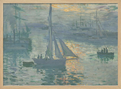 A framed print of Claude Monet's famous Impressionist painting, 'Impression, Sunrise'. The artwork depicts a misty harbor scene in muted blue and grey tones. A bright orange sun is visible through the haze, its light reflecting on the water's surface. Several boats, including a prominent sailboat in the foreground, are silhouetted against the dawn light. Print