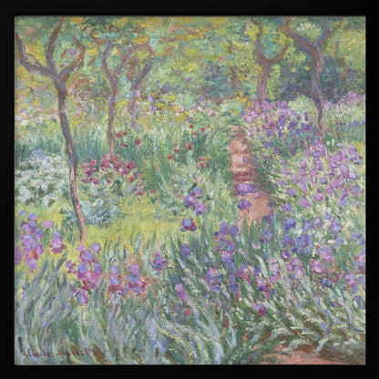 An impressionist painting by Claude Monet, 'The Artist's Garden at Giverny,' set in a light wood frame. The artwork depicts a lush, vibrant garden with a path winding through it. The foreground is dominated by purple irises and tall green leaves, while the background features trees and a mix of colorful flowers in shades of red, yellow, and white, all rendered with visible, textured brushstrokes. Print