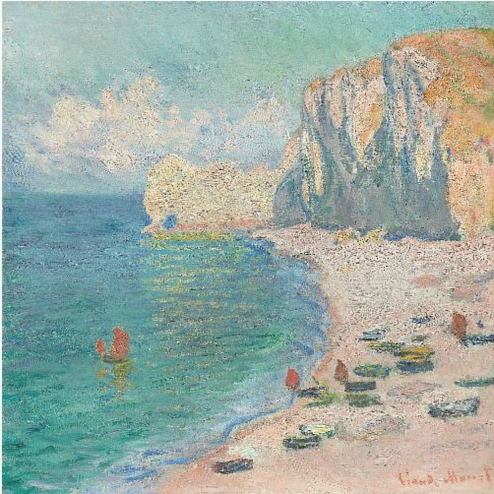 An impressionist painting by Claude Monet depicting the beach at Étretat, France, enclosed in a light wood frame. The artwork shows tall, light-colored cliffs on the right, a sandy beach with small boats, and vibrant turquoise water with a few red-sailed boats. The sky is partly cloudy. Decor