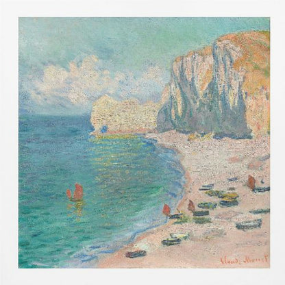 An impressionist painting by Claude Monet depicting the beach at Étretat, France, enclosed in a light wood frame. The artwork shows tall, light-colored cliffs on the right, a sandy beach with small boats, and vibrant turquoise water with a few red-sailed boats. The sky is partly cloudy. Decor