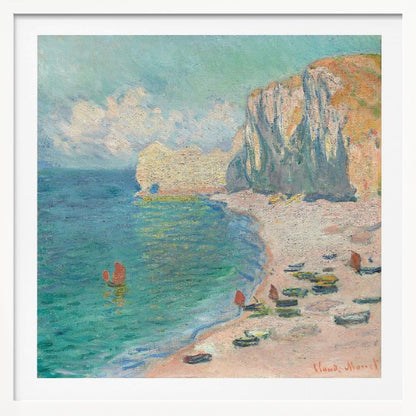An impressionist painting by Claude Monet depicting the beach at Étretat, France, enclosed in a light wood frame. The artwork shows tall, light-colored cliffs on the right, a sandy beach with small boats, and vibrant turquoise water with a few red-sailed boats. The sky is partly cloudy. Decor