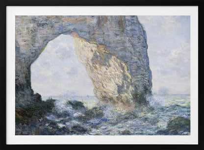 An impressionist painting by Claude Monet of the Manneporte rock arch at Étretat, France. Sunlight illuminates the massive stone arch as turbulent blue and white waves crash against the rocky shoreline below. The artwork is displayed in a silver frame. Decor
