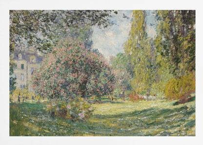 An impressionist painting by Claude Monet titled 'The Parc Monceau' displayed in a silver frame. The scene depicts a sunlit park with lush green grass, a large pink-flowering bush, and tall, leafy trees under a pale blue sky. Decor