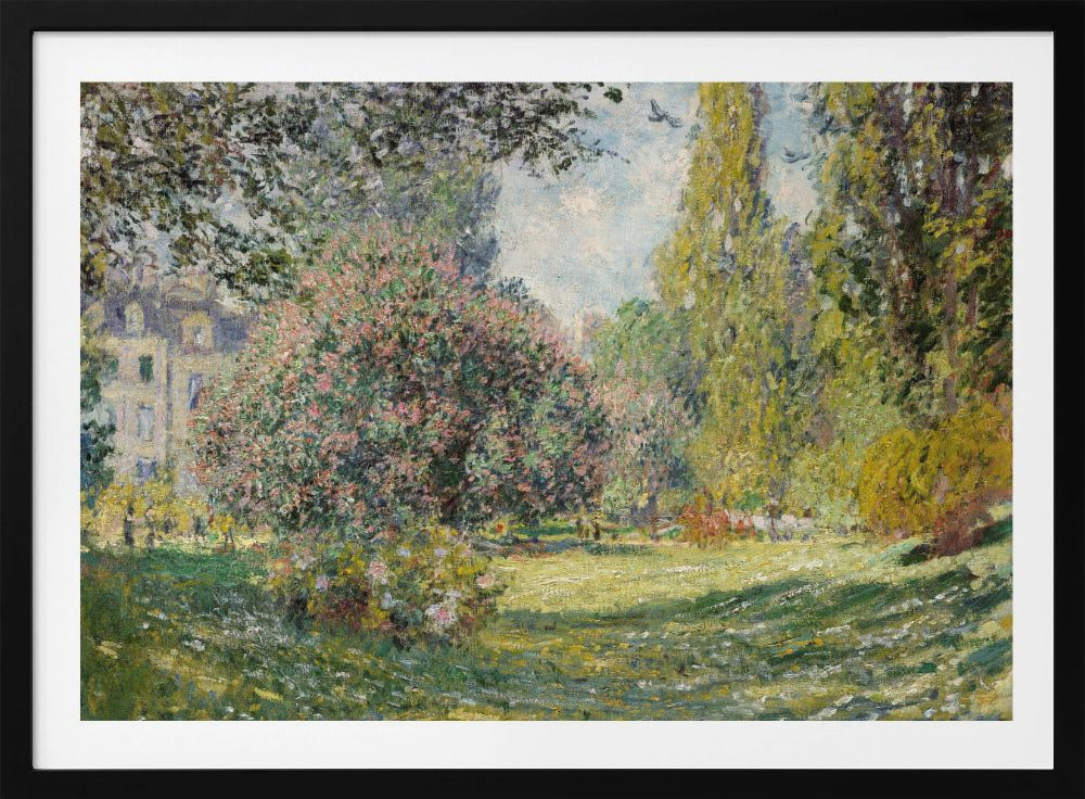 An impressionist painting by Claude Monet titled 'The Parc Monceau' displayed in a silver frame. The scene depicts a sunlit park with lush green grass, a large pink-flowering bush, and tall, leafy trees under a pale blue sky. Decor