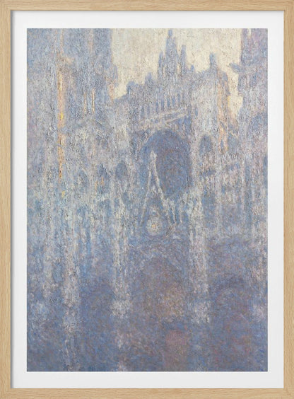 An Impressionist painting by Claude Monet depicting the Rouen Cathedral. The view is a close-up of the facade, rendered in hazy, textured brushstrokes with a predominantly blue, gray, and pale yellow color palette, suggesting early morning light or fog. The painting is enclosed in a simple black frame. Artwork