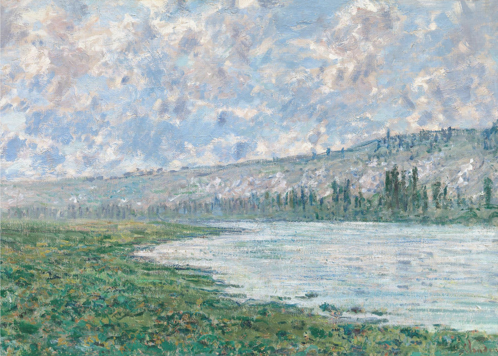 An Impressionist painting by Claude Monet, 'The Seine at Vétheuil', depicting a tranquil landscape. In the foreground, a lush green riverbank meets the calm, reflective water. A distant, soft-focus hillside rises under a vast sky filled with puffy white and grey clouds against a light blue background. The artwork is characterized by visible, textured brushstrokes and is displayed in a modern silver frame. Artwork
