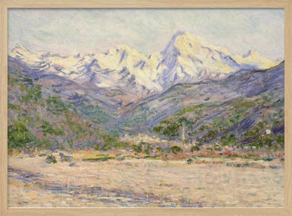 An impressionistic painting of a vast mountain range. The snow-covered peaks are bathed in pale yellow sunlight, while the lower slopes are cast in shades of purple and blue. A wide, beige valley with patches of green foliage sits in the foreground, all rendered with visible, textured brushstrokes and displayed in a silver frame. Print