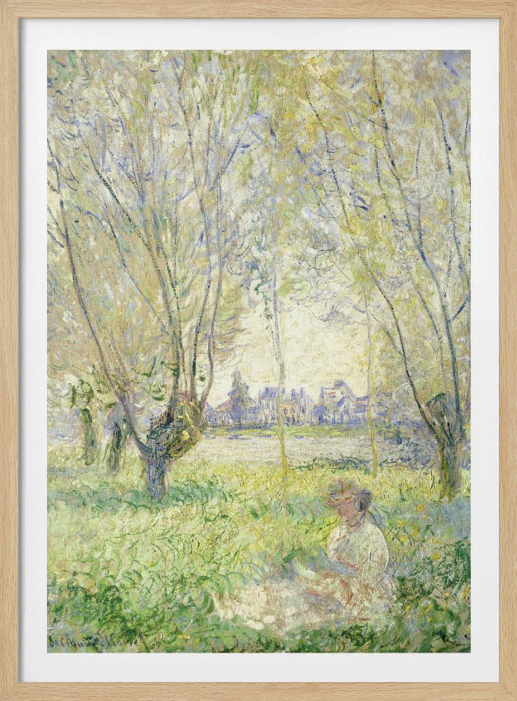 An Impressionist painting, 'Springtime' by Claude Monet, showing a woman in a hat sitting in a sunlit green field. Slender trees with light green foliage frame a view of a village across a river, evoking a peaceful spring day. The artwork is presented in a simple black frame. Artwork